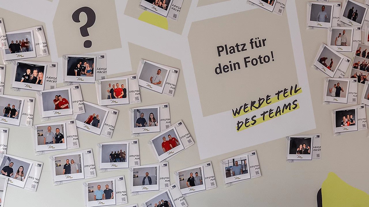 Fotowand mit Sofortbildern von Mitarbeitenden und Gästen sowie einem freien Platz für weitere Teamfotos.
